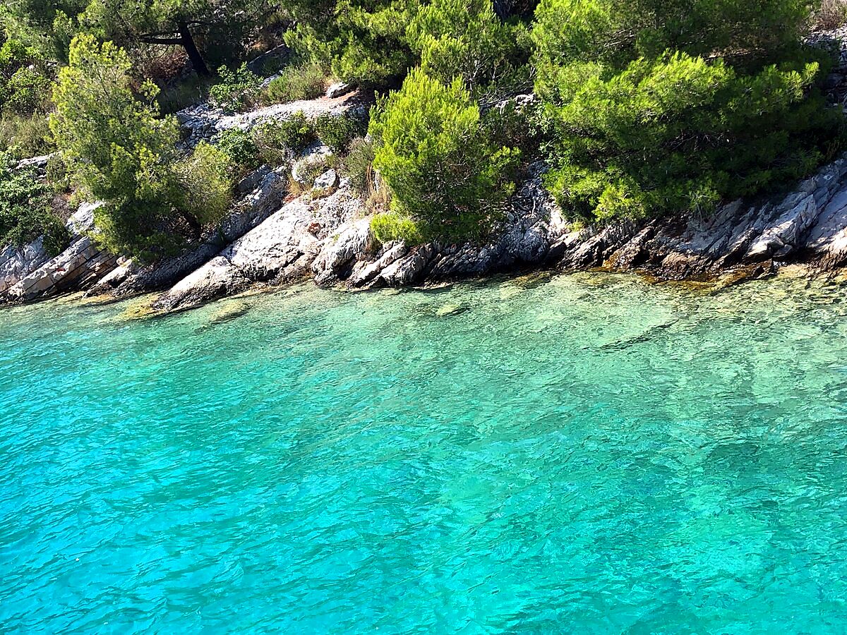 Crystal-clear turquoise water along the rocky shore of Šolta